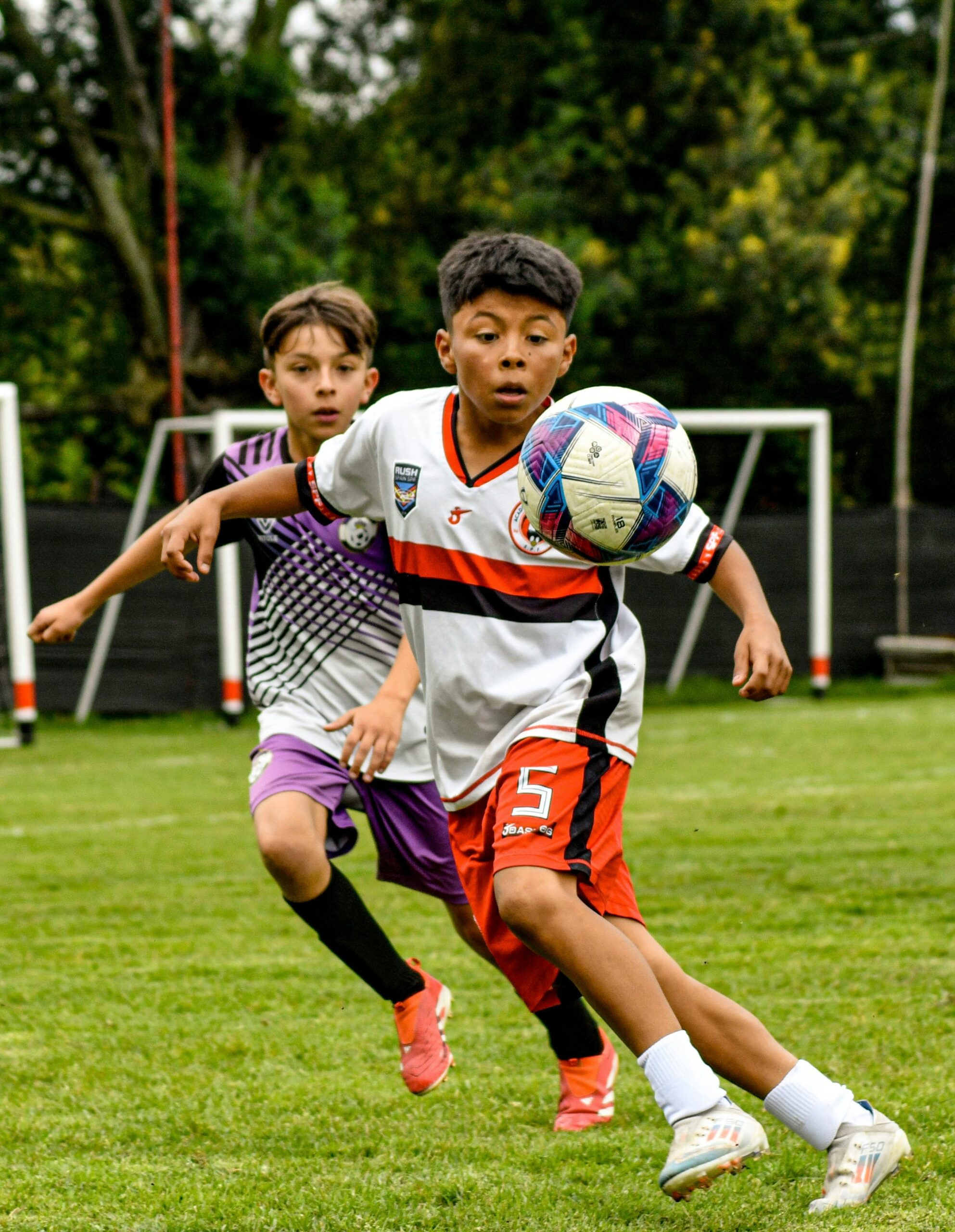 ボールに集中してプレイする2人の少年・屋外サッカーフィールド