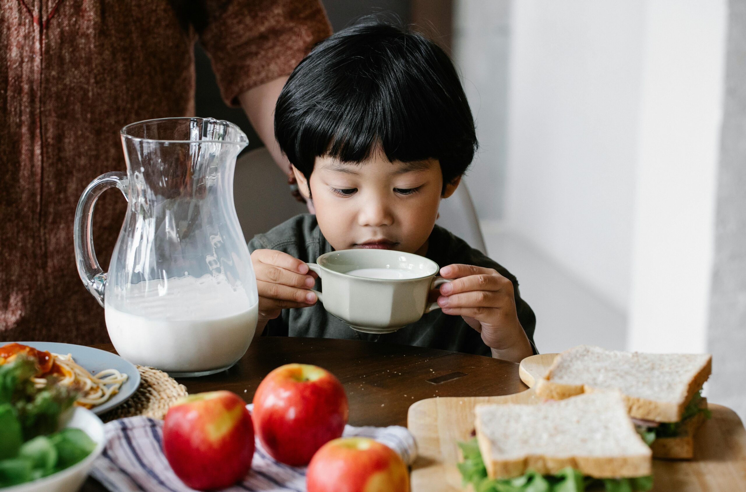 マグカップで牛乳を飲む男の子